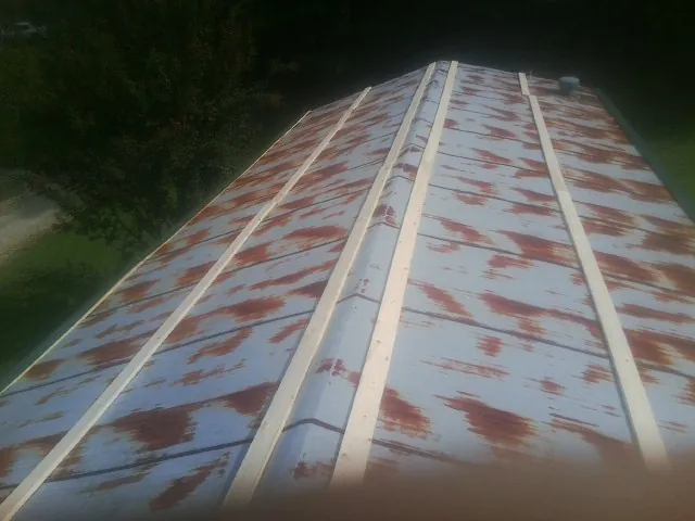 Rusted metal roof panels with new wood purlins before replacement — Storm Damage Roof Repair in Etna Green by Roofing Brothers