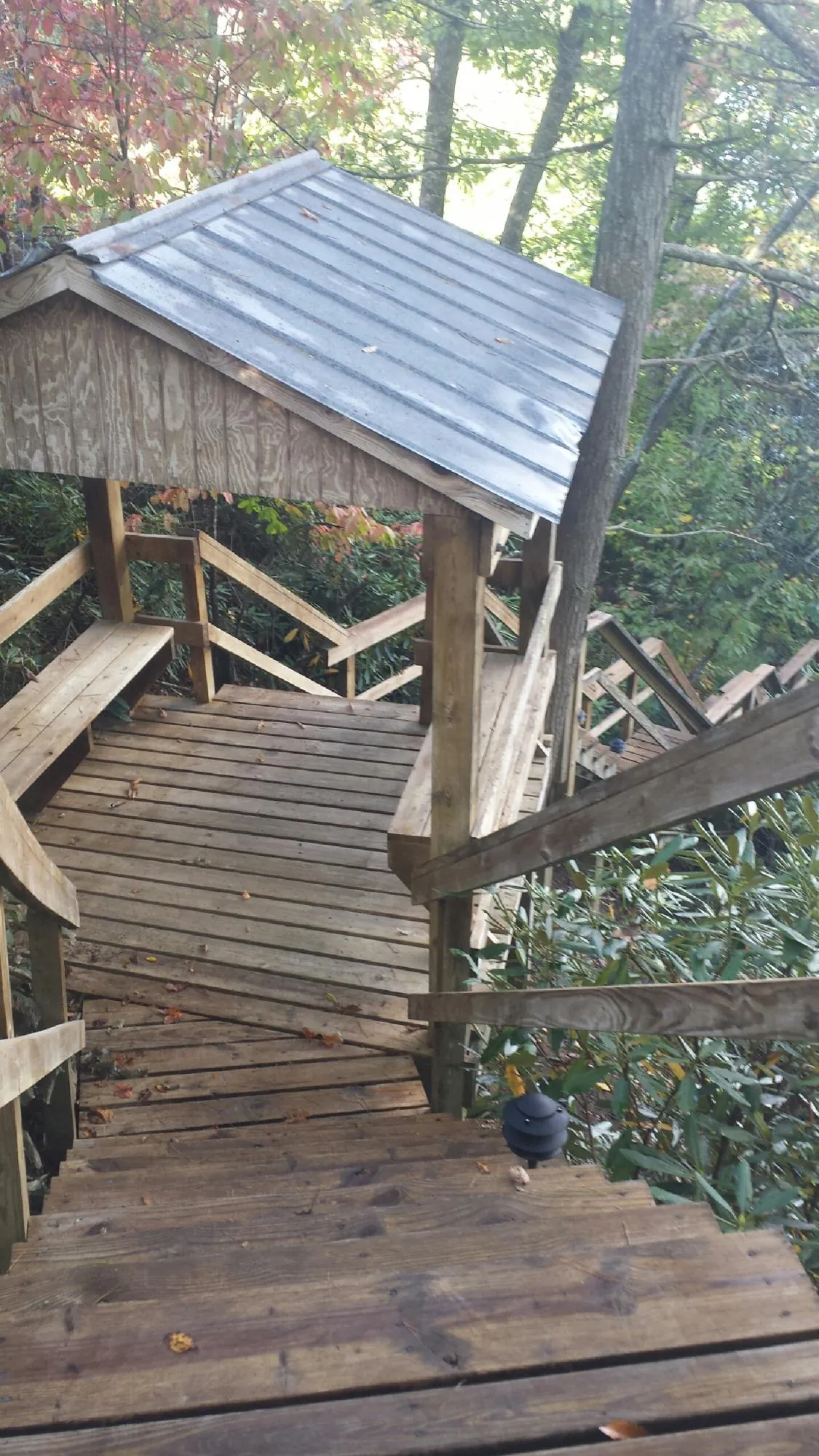 Metal roofed shelter over wooden steps on a wooded walkway — Skylight Repair & Installation work by our crew in Etna Green