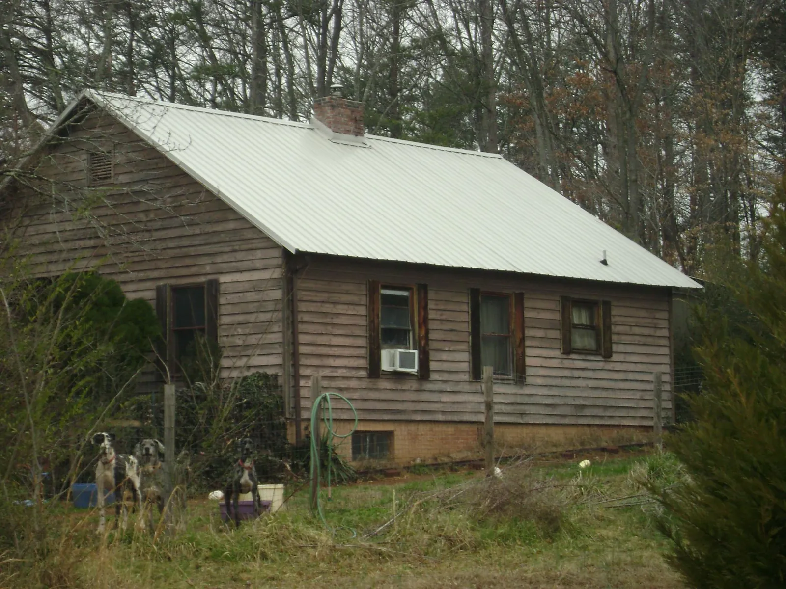 White metal roof on an old wood sided farmhouse, from a Metal Roof Installation job in Etna Green